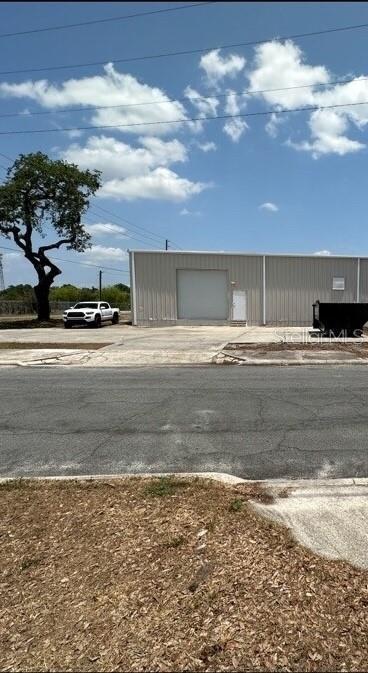 A white pickup truck is parked in front of a metal industrial building under a blue sky — 1604 OLIVE STREET, LAKELAND, FL