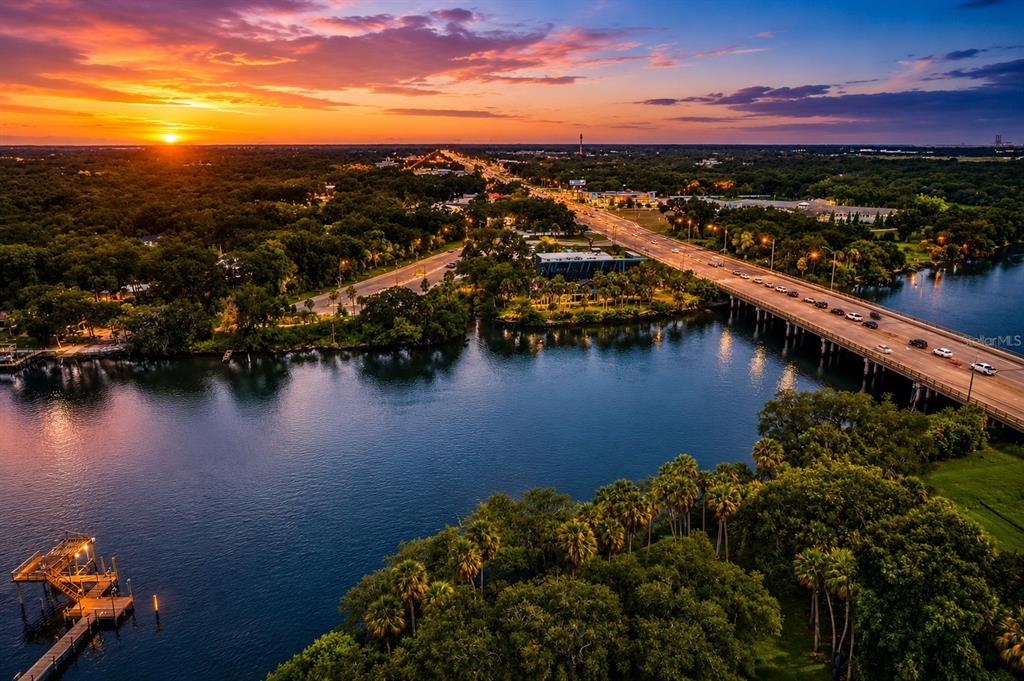 An aerial view shows a bridge crossing a river at sunset near a wooded area — RIVERVIEW DRIVE, RIVERVIEW, FL