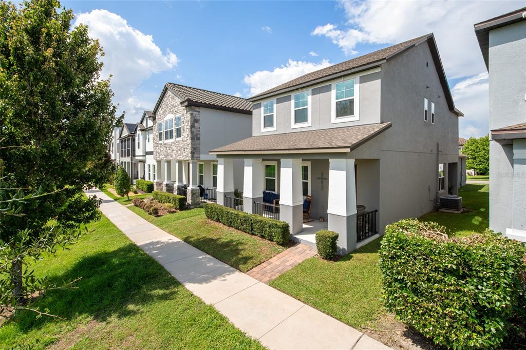 A row of two-story suburban houses with front porches and manicured lawns along a sidewalk — 2241 WHITE FEATHER LOOP, OAKLAND, FL