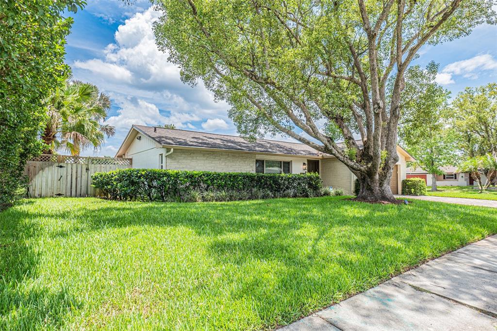 A single-story house with a brown garage door sits on a corner lot with trees — 741 BROOKSIDE ROAD, MAITLAND, FL