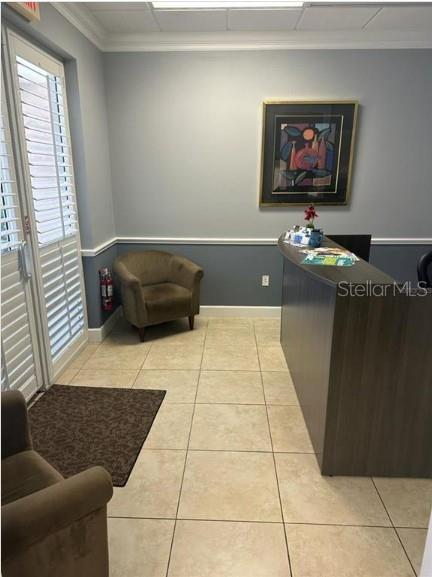 A reception area features a dark wood desk, a tan armchair, and light-colored tile flooring — 5245 OFFICE PARK BOULEVARD UNIT 102, BRADENTON, FL