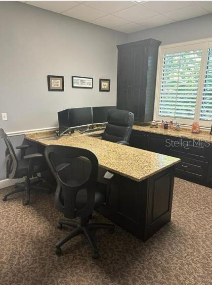 An office features a large L-shaped granite desk, dark cabinetry, and two black rolling chairs — 5245 OFFICE PARK BOULEVARD UNIT 102, BRADENTON, FL