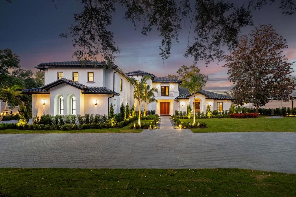 A two-story white stucco house with a dark tile roof and a paved driveway — 9725 CHESTNUT RIDGE DRIVE, WINDERMERE, FL