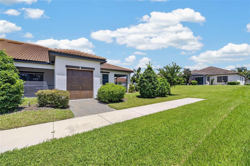 A single-story house with a brown garage door, tiled roof, and a concrete walkway — 5325 STOIC VALE DRIVE, WIMAUMA, FL