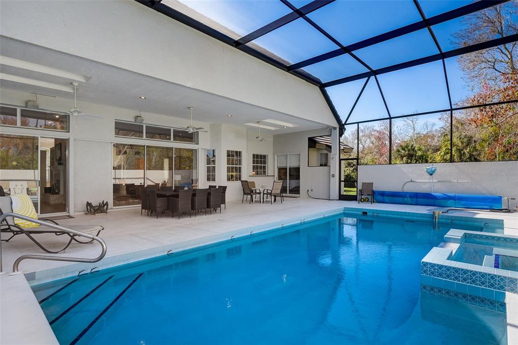 A covered patio with a swimming pool and spa enclosed by a screen cage — 4653 HADFIELD DRIVE, SARASOTA, FL
