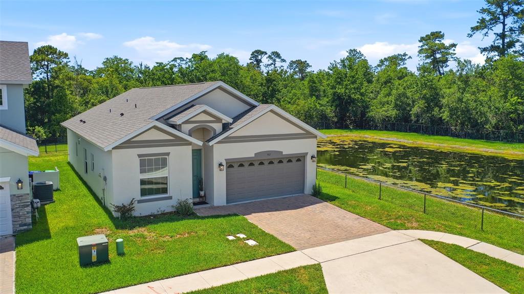 An aerial view of a single-story house with a garage and a pond in back — 802 REFLECTION LAKE DRIVE, ORLANDO, FL