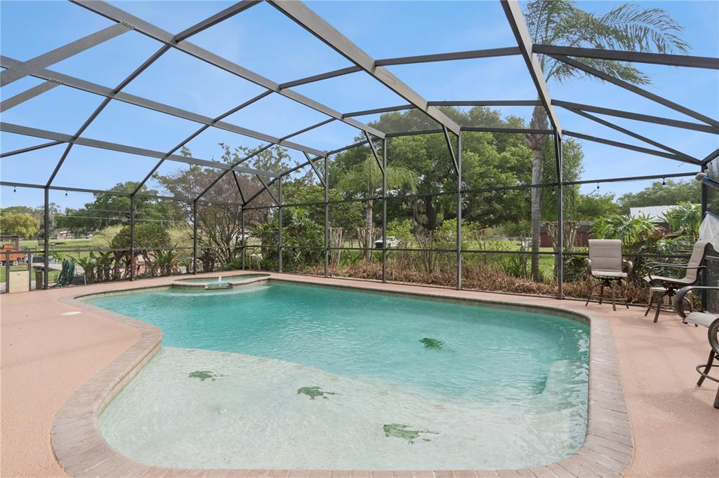 A single-story house with a red metal roof and wood siding sits behind a large tree — 2925 GODWIN ROAD, ST CLOUD, FL