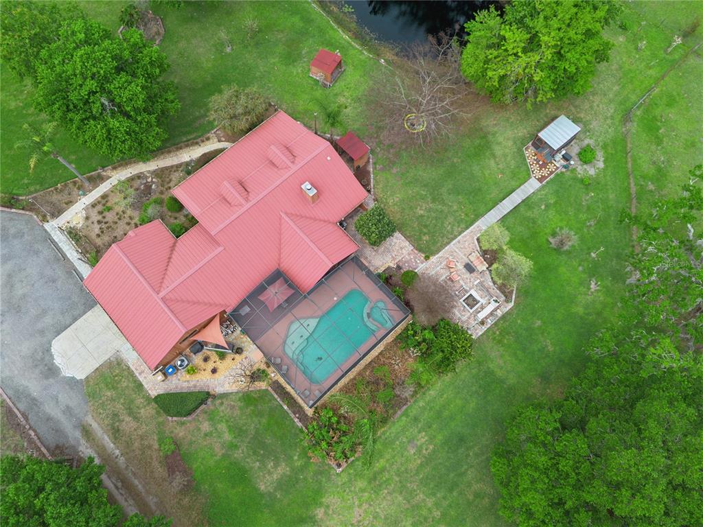 A single-story house with a red metal roof and a front porch sits on grass — 2925 GODWIN ROAD, ST CLOUD, FL