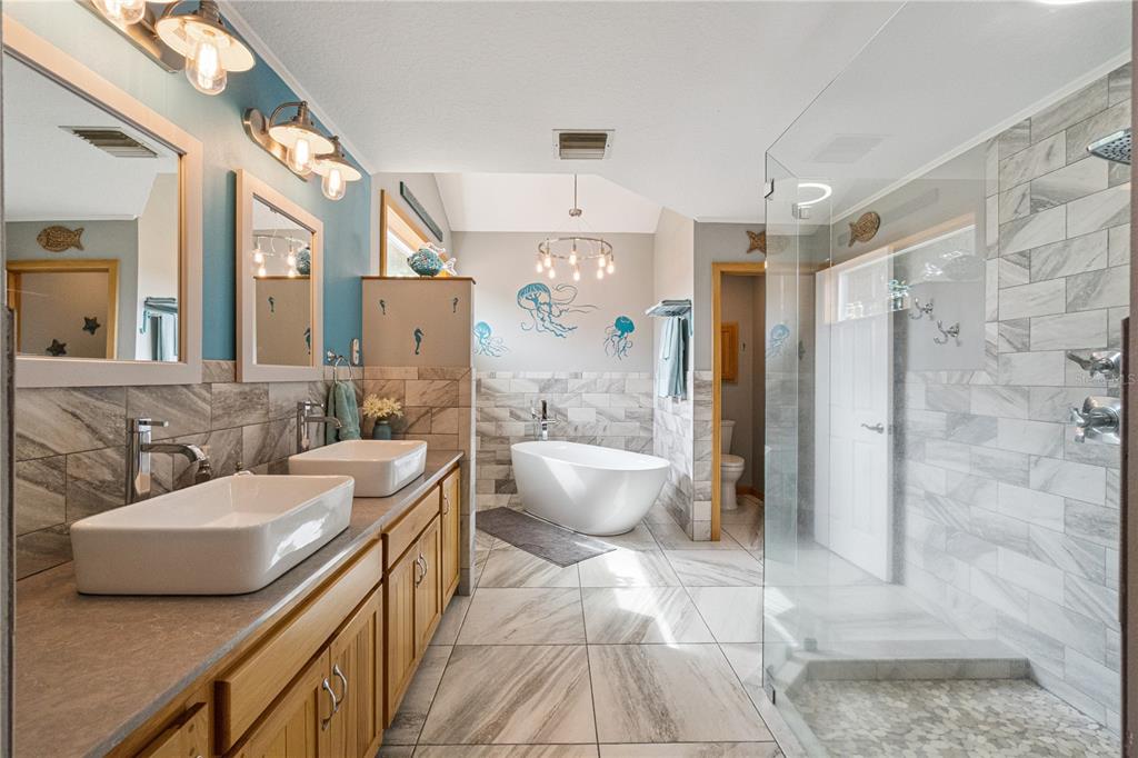 An entryway features a white front door with glass panels, tile flooring, and a bench — 2925 GODWIN ROAD, ST CLOUD, FL