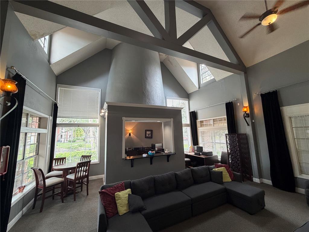 A living room features vaulted ceilings, a central bar area, and large windows with blinds — 10200 GANDY BOULEVARD N UNIT 418, ST PETERSBURG, FL