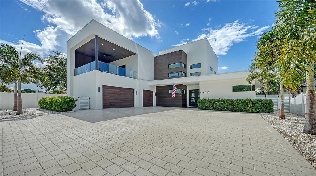 A modern two-story house with a paved driveway, wood accents, and a second-floor balcony — 1960 BOYCE STREET, SARASOTA, FL