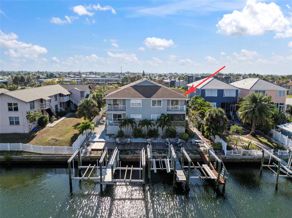 An aerial view shows a multi-story waterfront building with boat docks and a wooden deck — 1013 APOLLO BEACH BOULEVARD UNIT 203, APOLLO BEACH, FL