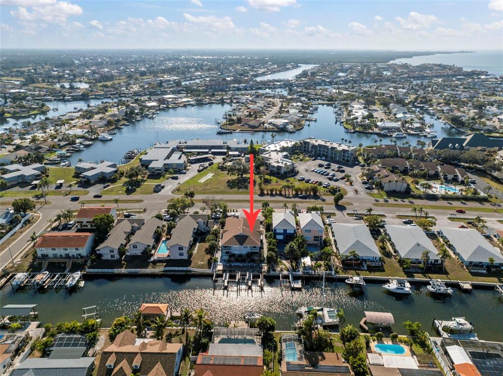 An aerial view shows a waterfront residential property with a boat dock and canal access — 1013 APOLLO BEACH BOULEVARD UNIT 203, APOLLO BEACH, FL