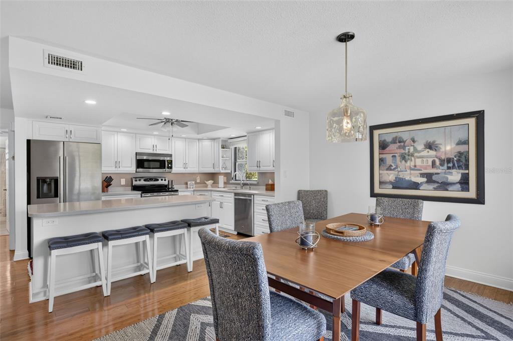 A kitchen with white cabinets and stainless steel appliances opens to a dining area — 1610 ISLAMORADA BOULEVARD UNIT 61B, PUNTA GORDA, FL