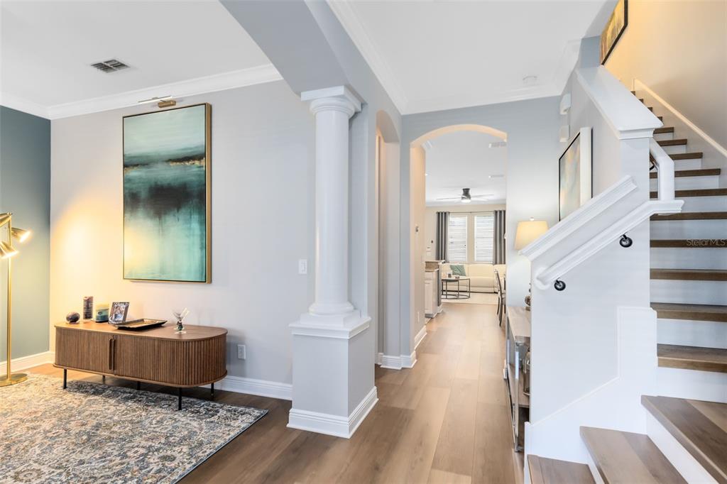 A foyer with light wood floors, a white column, and a staircase leading upstairs — 463 ELLIS SQUARE COURT, SANFORD, FL