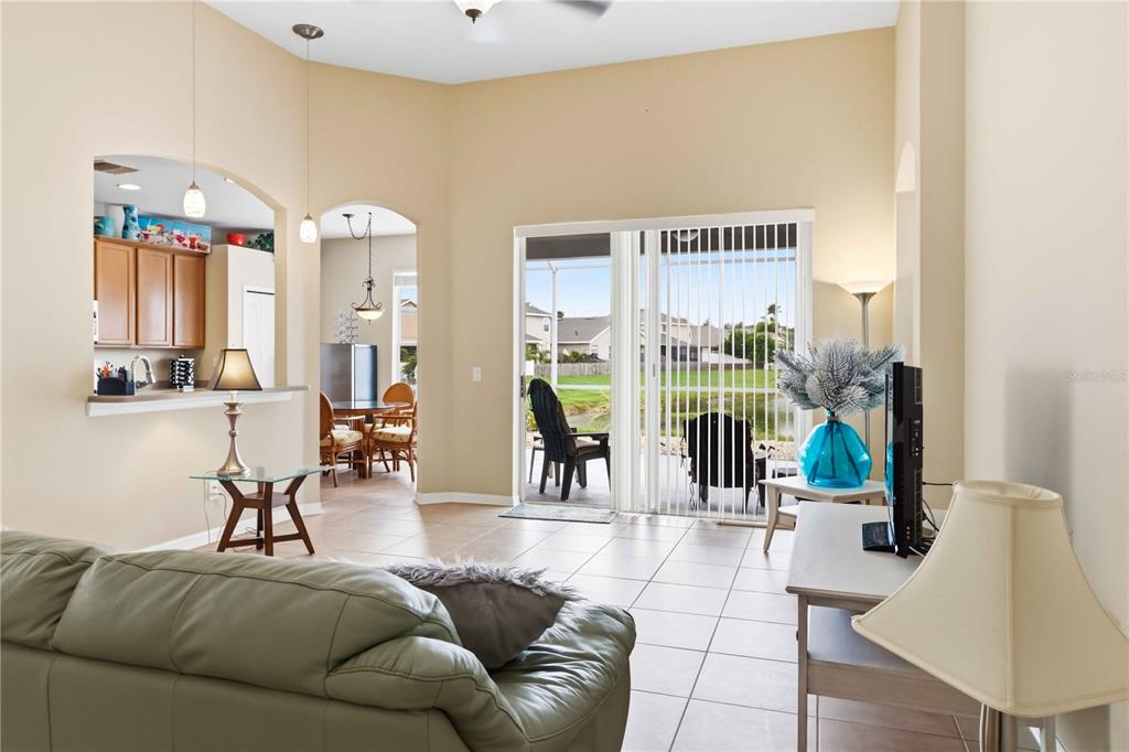 A living room features light tile flooring, a light blue sofa, and a ceiling fan — 408 DURHAM SHORE COURT, APOLLO BEACH, FL