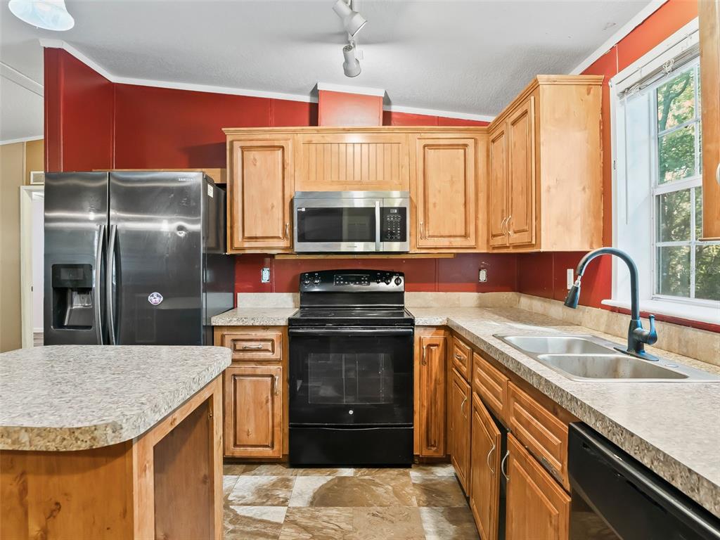 A covered wooden deck features a rustic outdoor kitchen area and a white entry door — 3861 CR 519, COLEMAN, FL