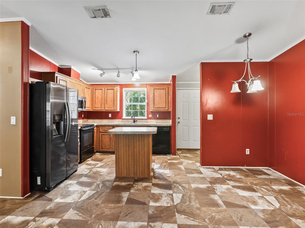 An outdoor kitchen area features a wooden counter, a sink, and a built-in double oven — 3861 CR 519, COLEMAN, FL