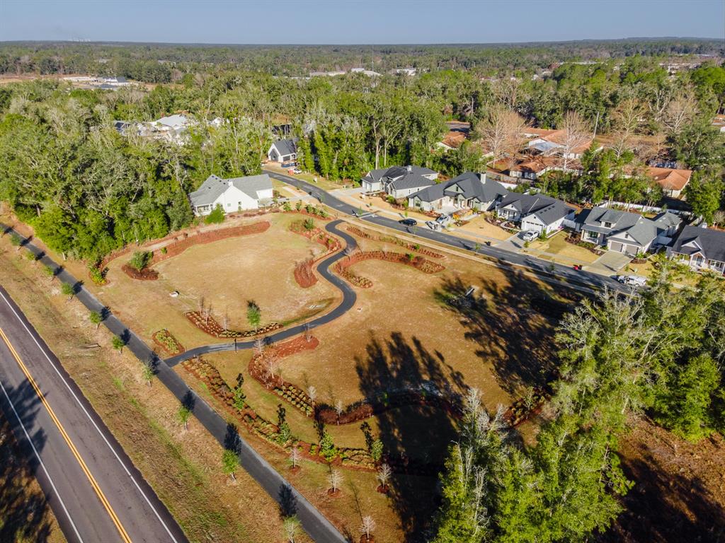 An aerial view shows several modern houses nestled among trees in a suburban neighborhood — 14110 SW 7TH PLACE, NEWBERRY, FL
