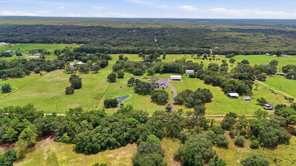 An aerial view shows a rural property with a house, outbuildings, and a small pond — 1750 W MANSFIELD STREET, LECANTO, FL