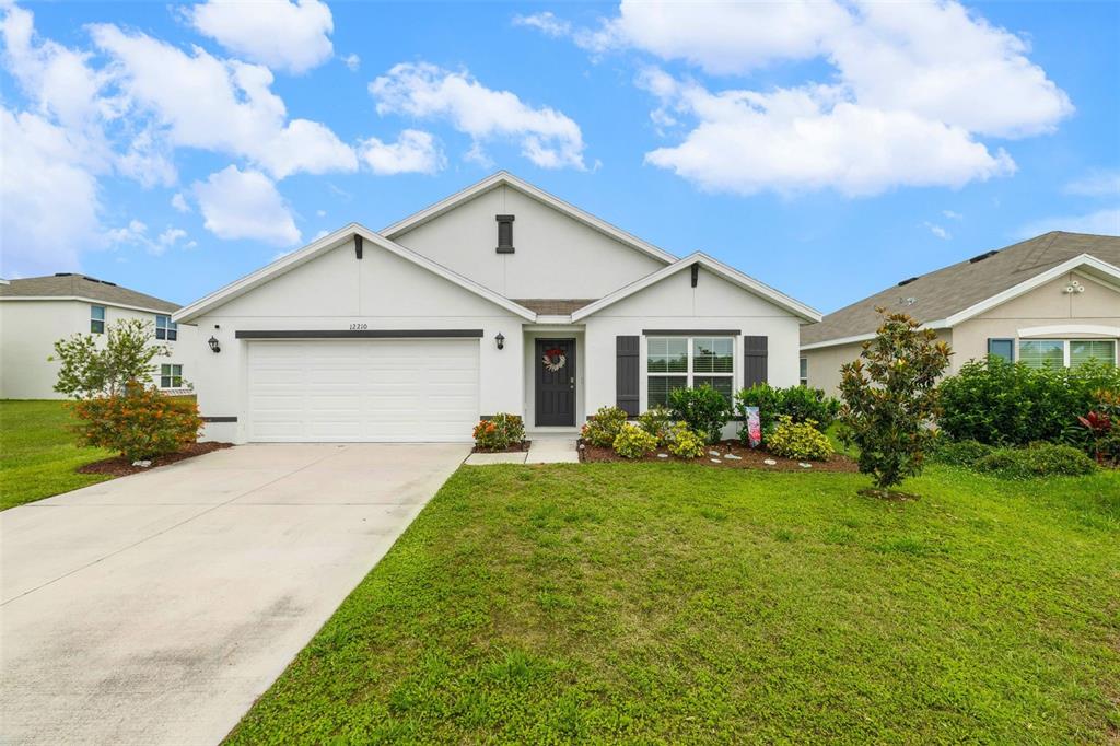 A dining area with a wooden table and chairs sits adjacent to an open kitchen — 12210 KINGSLEY TRAIL, PARRISH, FL
