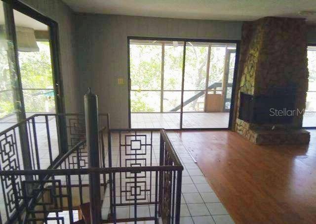 A room with tile flooring, wood-paneled walls, a drop ceiling, and a spiral staircase — 3339 E WITHLACOOCHEE TRAIL, DUNNELLON, FL
