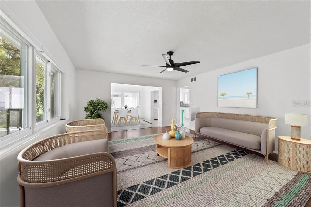 A living room features a curved sofa, two matching armchairs, a round coffee table, and rug — 3915 SCHWALBE DRIVE UNIT 128, SARASOTA, FL