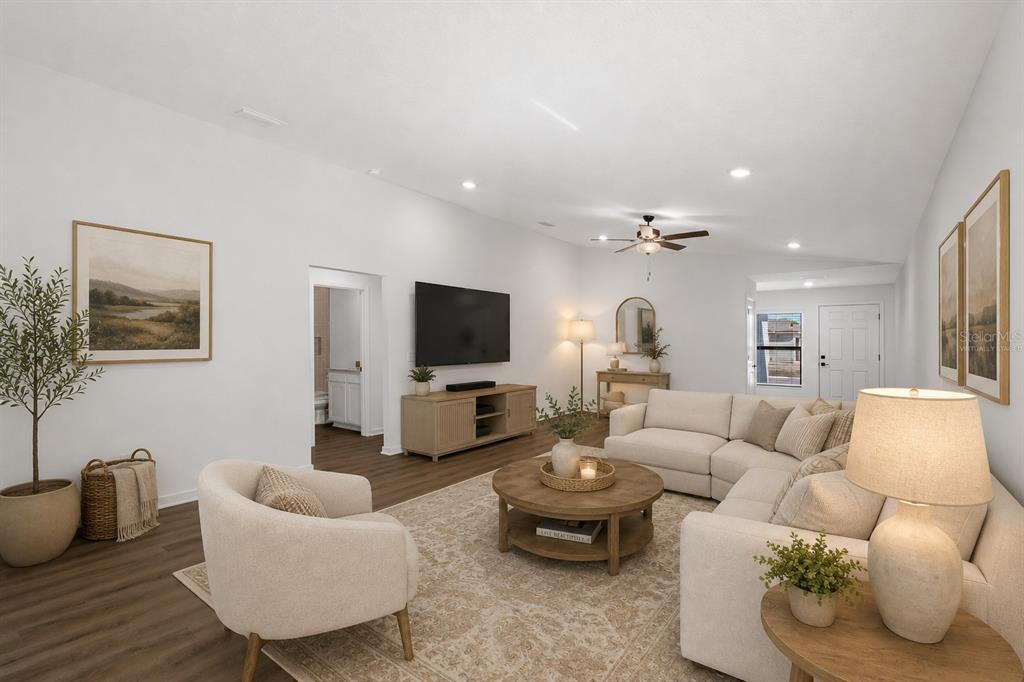 A living room features a sectional sofa, a round coffee table, and a wall-mounted television — 14133 CANADA GOOSE ROAD, WEEKI WACHEE, FL