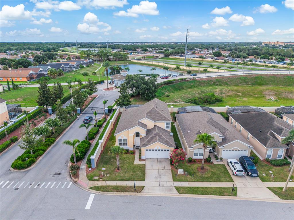 An aerial view shows a suburban house with a two-car garage and a screened pool — 8184 FAN PALM WAY, KISSIMMEE, FL