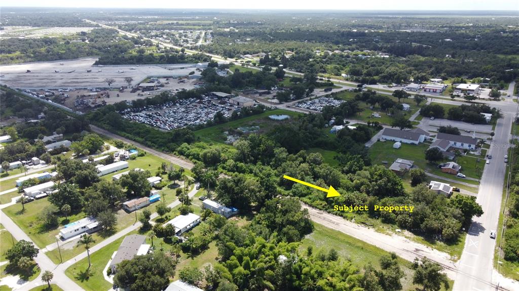An aerial view shows a wooded, undeveloped lot marked as the subject property near roads — CLEVELAND AVENUE, PUNTA GORDA, FL