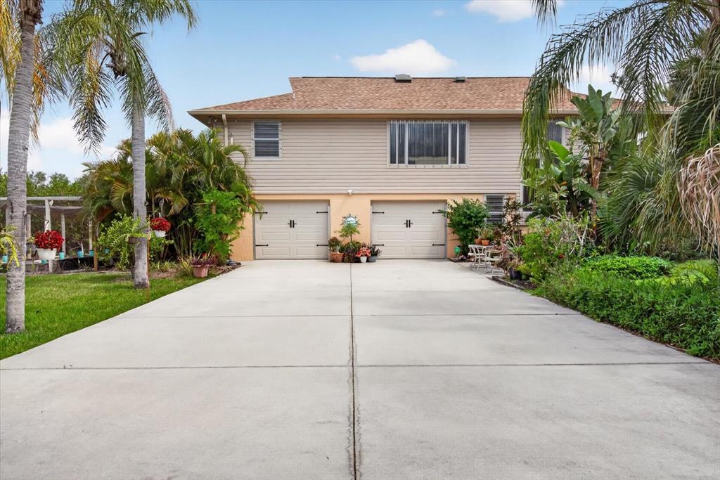 A two-story house features a concrete driveway leading to two attached garage doors — 4190 STROMBUS ROAD, VENICE, FL