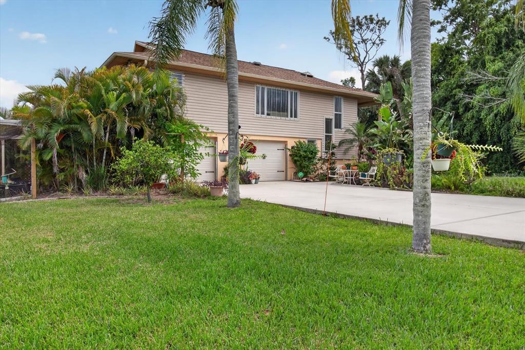 A two-story house with beige siding, two garage doors, and a concrete driveway — 4190 STROMBUS ROAD, VENICE, FL