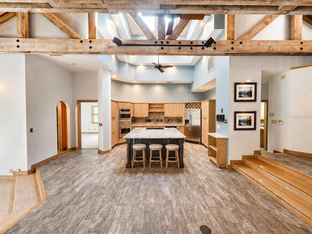 A kitchen with a central island, light wood cabinetry, and exposed wooden ceiling beams — 3522 SHORELINE CIRCLE, PALM HARBOR, FL
