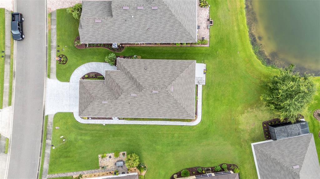 An aerial view shows a suburban house with a gray roof, driveway, and surrounding lawn — 2309 LAKE JAMES WAY, LAKELAND, FL