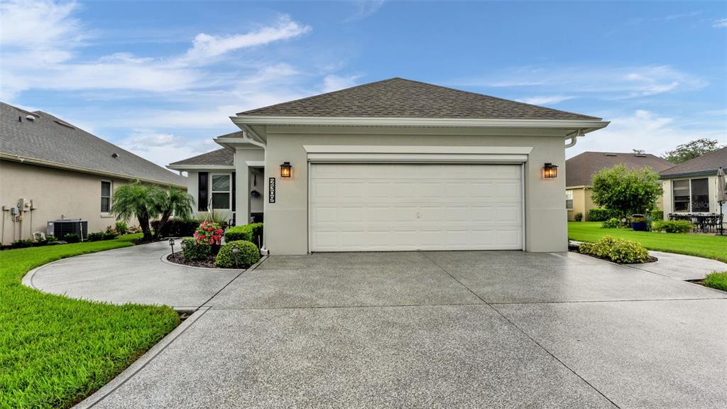 A single-story house features a two-car garage, a concrete driveway, and a landscaped front yard — 2309 LAKE JAMES WAY, LAKELAND, FL