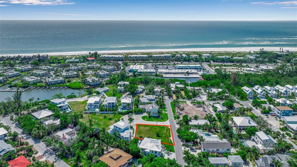 An aerial view shows a vacant rectangular lot surrounded by residential houses near the ocean — 610 HIBISCUS WAY, LONGBOAT KEY, FL