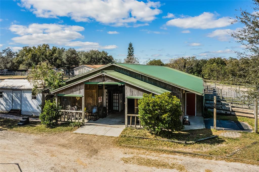 A wooden barn with a green metal roof sits on a dirt lot with fencing — 1455 W KEENE ROAD, APOPKA, FL