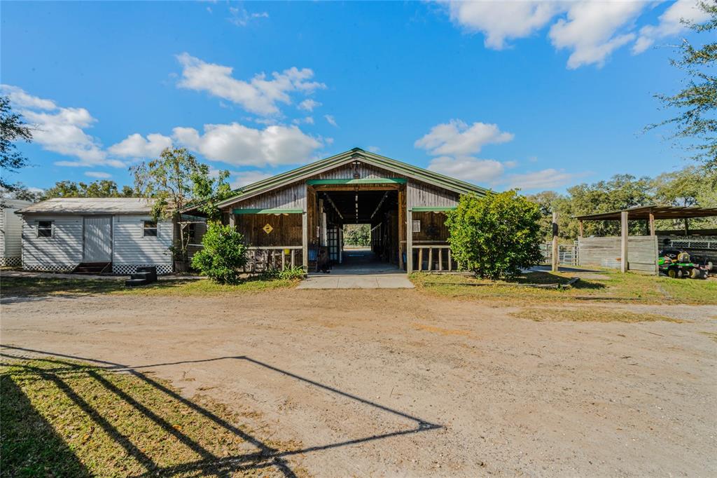 A wooden barn with a central breezeway stands next to a small white shed — 1455 W KEENE ROAD, APOPKA, FL