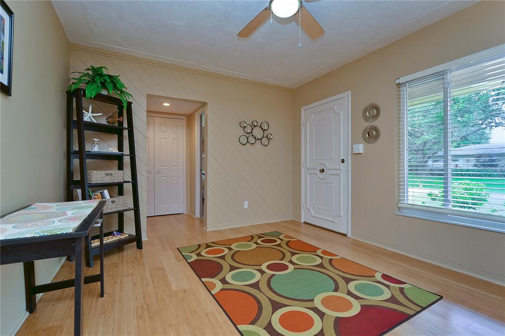 A room with light wood flooring, a patterned area rug, a bookshelf, and a window — 5850 24TH AVENUE S, GULFPORT, FL