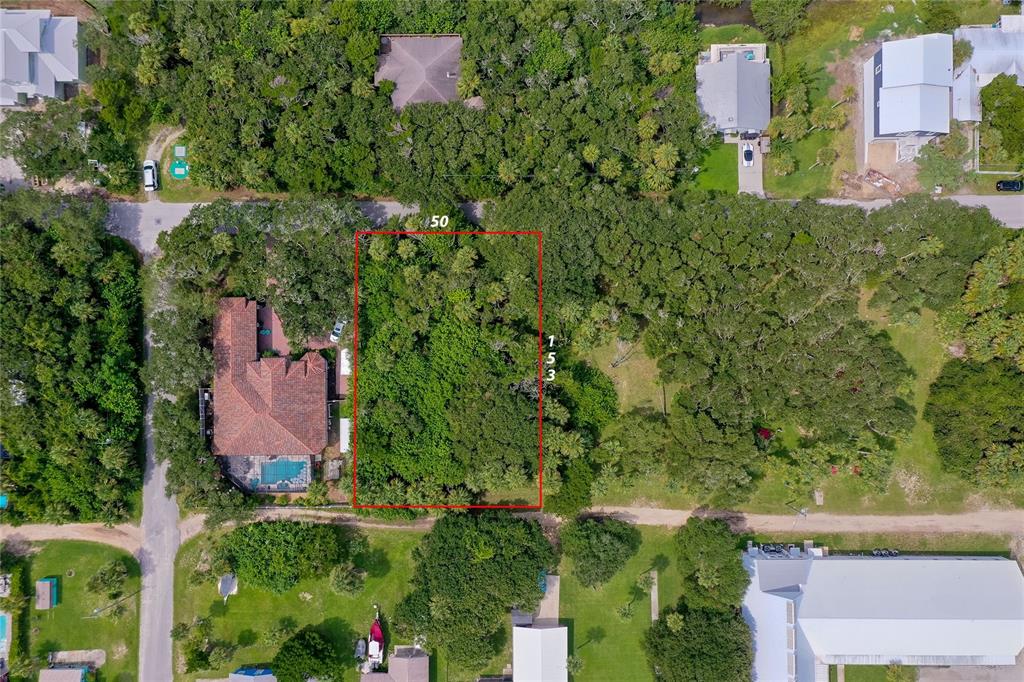An aerial view shows a coastal neighborhood with houses nestled among trees near the ocean — 0 S FLAGLER, FLAGLER BEACH, FL