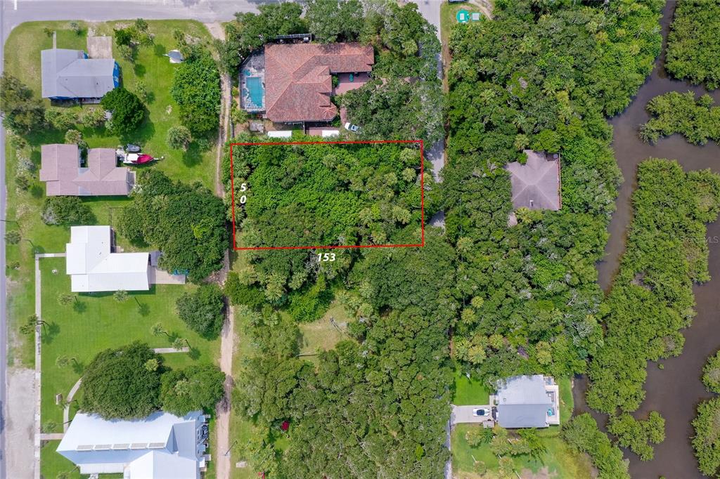 An aerial view shows a residential property with a house, pool, and surrounding wooded area — 0 S FLAGLER, FLAGLER BEACH, FL