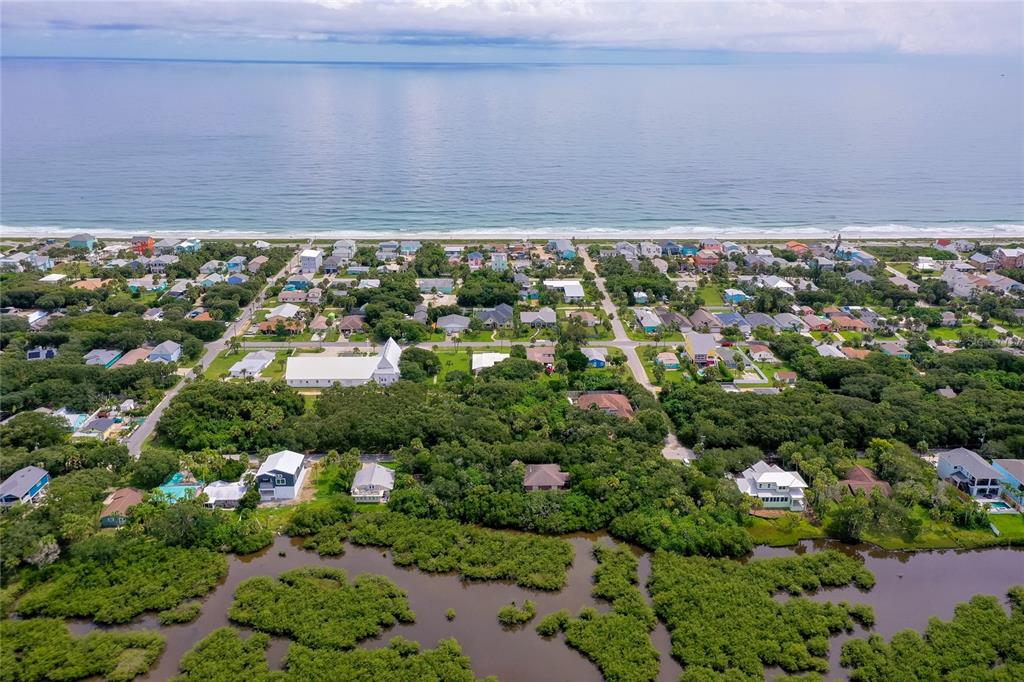 An aerial view shows a wooded residential lot near the ocean and a coastal marsh — 0 S FLAGLER, FLAGLER BEACH, FL