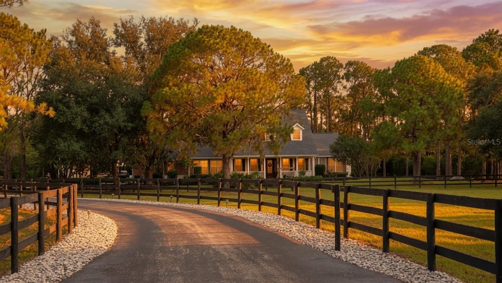 A view from a porch overlooking a grassy yard with landscaping and a wooden fence — 20011 65TH AVENUE E, BRADENTON, FL