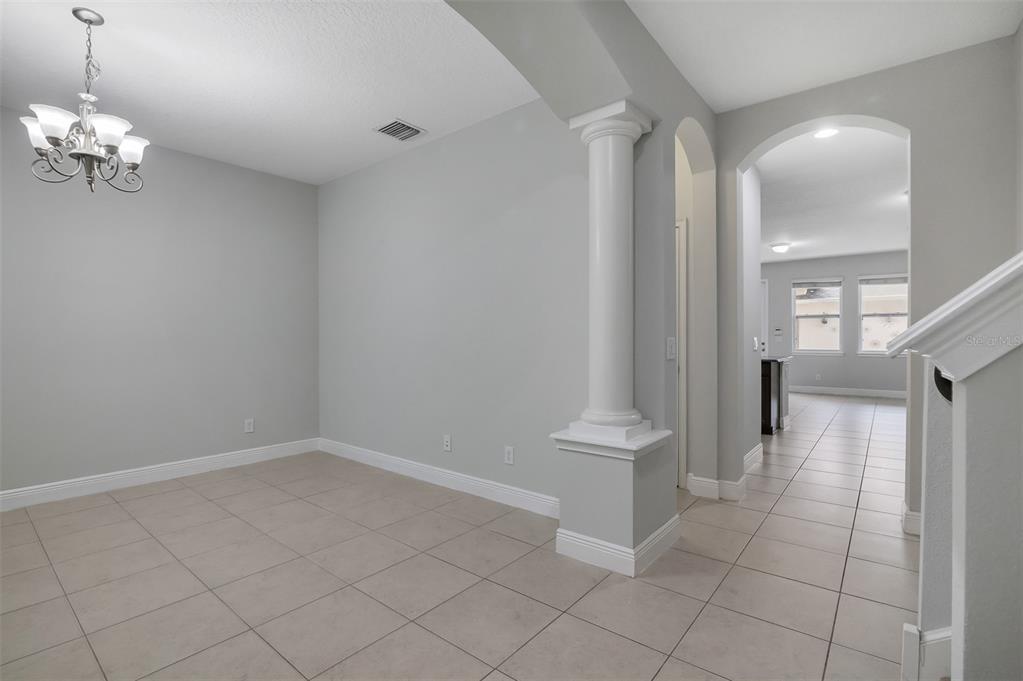 A dining area features light gray walls, tile flooring, a chandelier, and a decorative column — 12357 VIA DERNA PLACE, WINDERMERE, FL