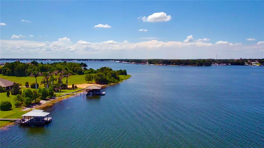 An aerial view shows a lakefront property with two boat docks and lush green landscaping — 466 SUNSET POINTE DRIVE, LAKE PLACID, FL