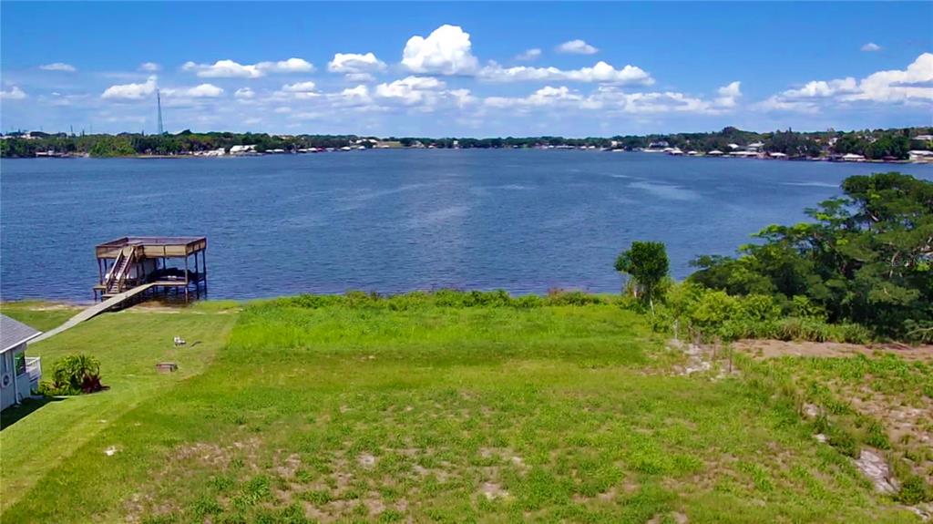 An aerial view of a grassy waterfront lot featuring a wooden boat dock on a lake — 466 SUNSET POINTE DRIVE, LAKE PLACID, FL