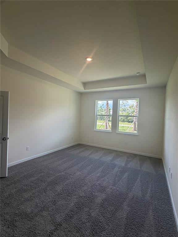 A tan community center building features a covered patio, palm trees, and a parking lot — 3024 KINGSMAN TRAIL, ORMOND BEACH, FL