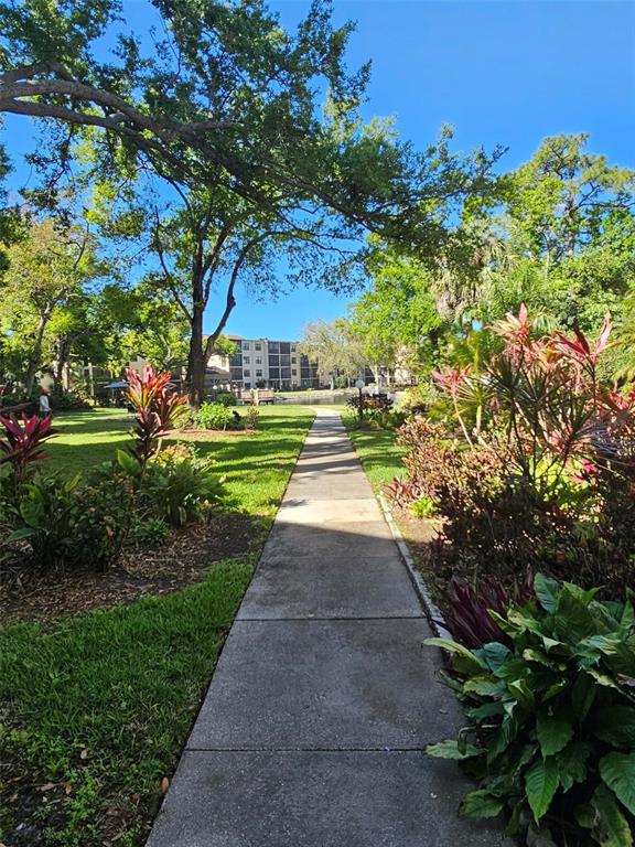 A pond with a fountain sits in front of multi-story apartment buildings and trees — 315 30TH AVENUE W UNIT B307, BRADENTON, FL