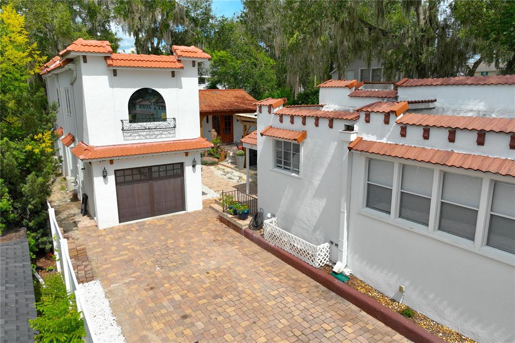 An exterior view of a white stucco house with a red tile roof and driveway — 229 E 6TH AVENUE, MOUNT DORA, FL