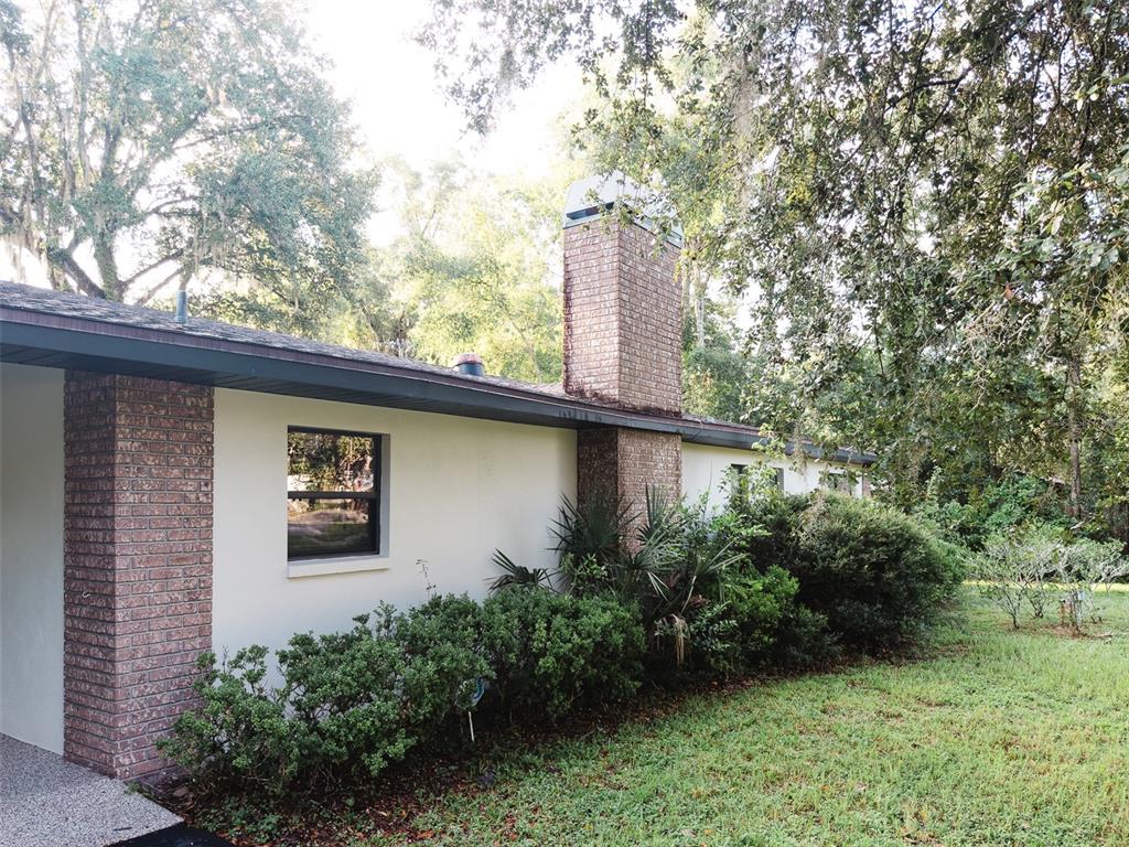 A covered carport with a textured ceiling, concrete floor, and a view of the driveway — 4367 S US 301, BUSHNELL, FL